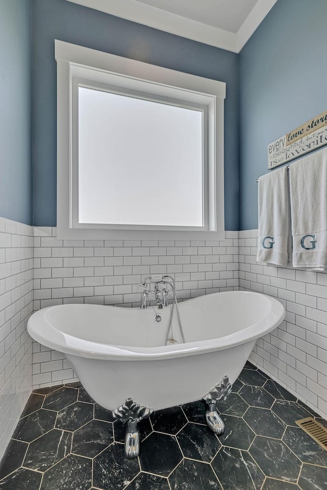 bathroom with tile walls and a bath