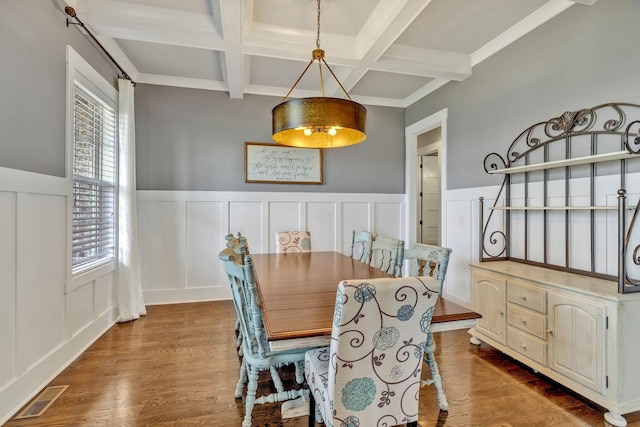 dining room featuring hardwood / wood-style flooring, coffered ceiling, and beamed ceiling