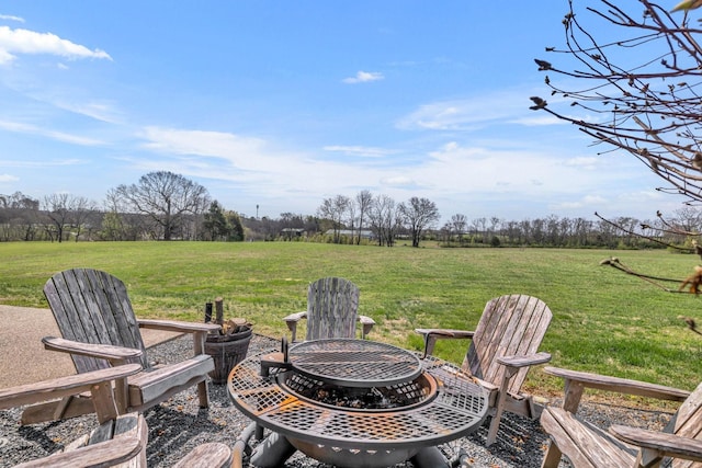 view of patio with a rural view and an outdoor fire pit