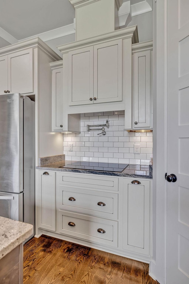 kitchen featuring white cabinetry, black electric stovetop, stainless steel fridge, and dark hardwood / wood-style floors