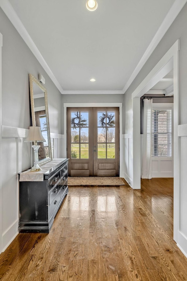 entryway with crown molding, hardwood / wood-style floors, and french doors