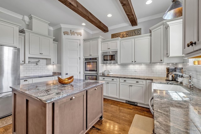 kitchen featuring white cabinetry, appliances with stainless steel finishes, light stone counters, and beam ceiling