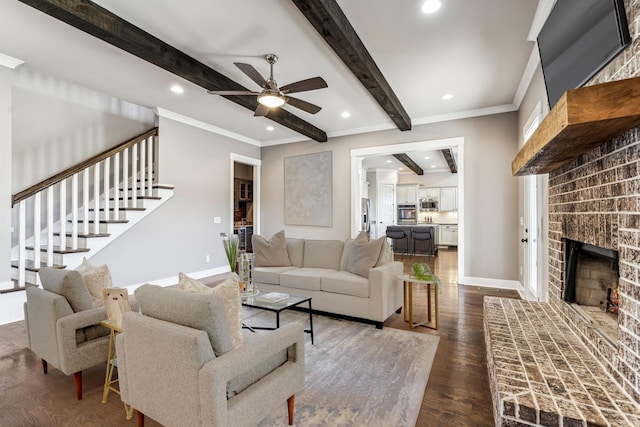 living room featuring crown molding, a brick fireplace, dark hardwood / wood-style flooring, ceiling fan, and beam ceiling