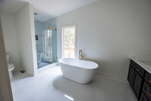 bathroom featuring a freestanding bath, toilet, a shower stall, vanity, and baseboards