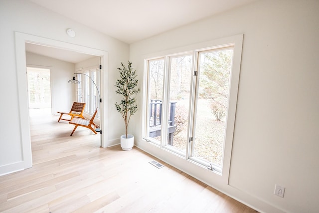 interior space featuring light wood finished floors, plenty of natural light, and visible vents