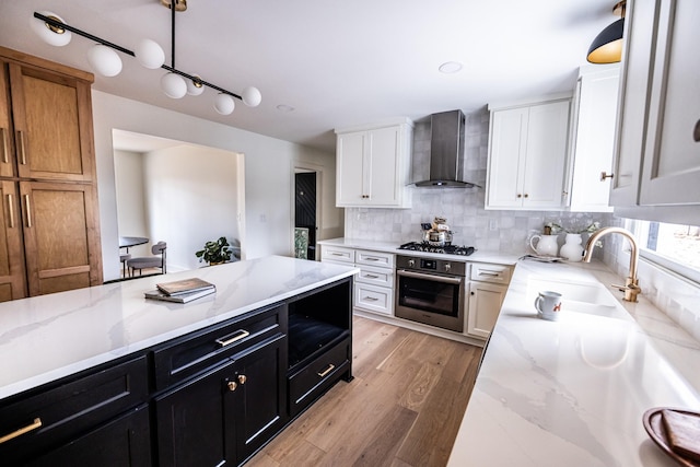 kitchen with wall chimney exhaust hood, appliances with stainless steel finishes, dark cabinetry, and white cabinets