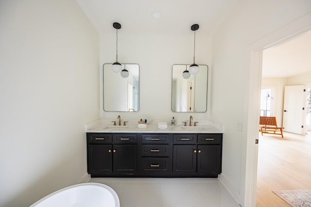 bathroom with double vanity, a sink, and baseboards