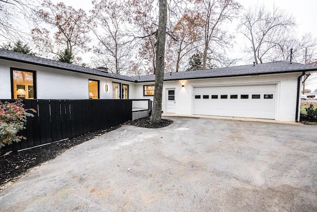 view of front of house with a fenced front yard, driveway, and an attached garage