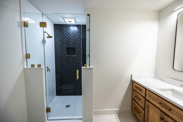 full bathroom featuring a stall shower, baseboards, and vanity