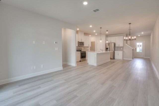 unfurnished living room featuring light hardwood / wood-style flooring and a chandelier