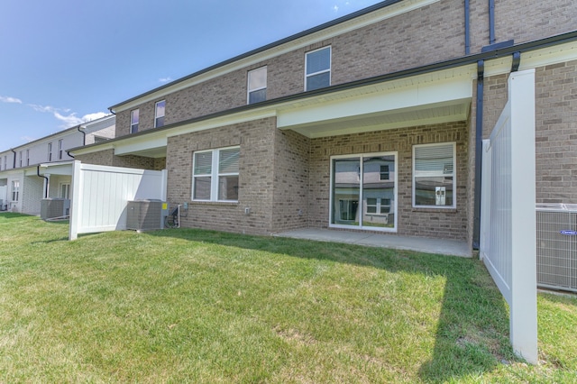 rear view of property featuring central AC and a lawn