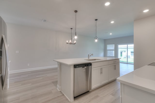 kitchen with sink, a center island with sink, pendant lighting, stainless steel appliances, and white cabinets