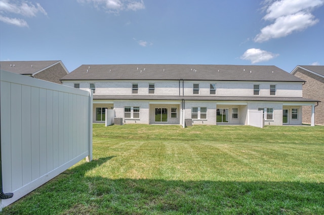 rear view of house featuring a yard and central air condition unit