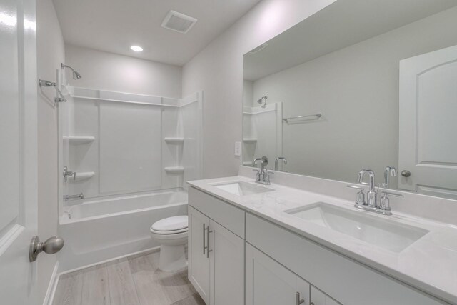 full bathroom with hardwood / wood-style flooring, vanity, toilet, and shower / bathing tub combination