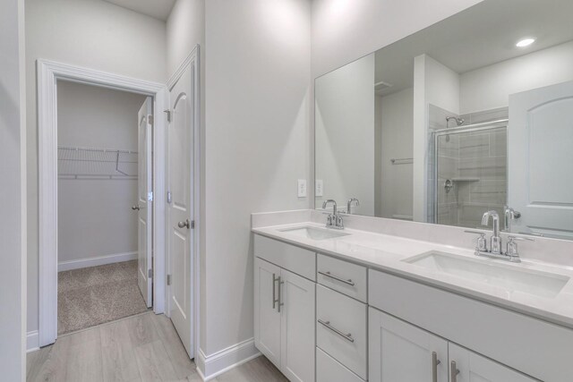 bathroom featuring vanity, an enclosed shower, and wood-type flooring