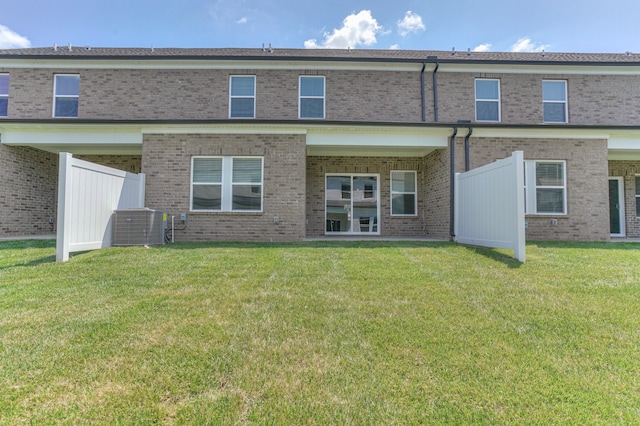 back of property with a lawn and central air condition unit