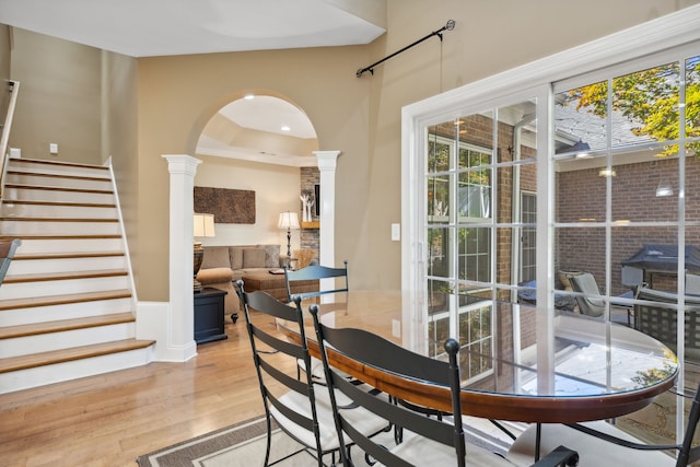 dining room featuring ornate columns and light hardwood / wood-style flooring