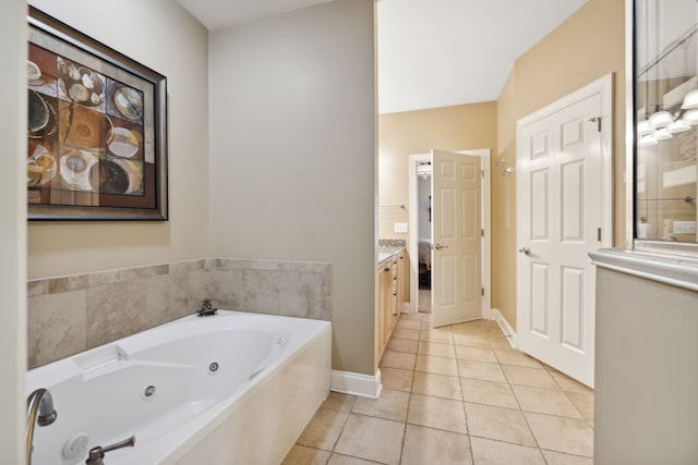 bathroom featuring tile patterned floors, tiled tub, and vanity