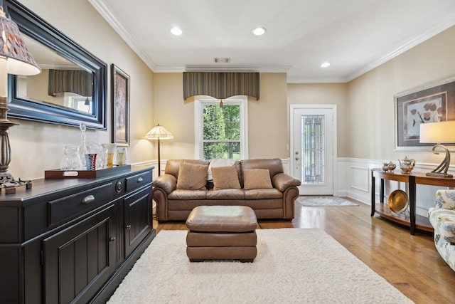 living room with crown molding and light wood-type flooring