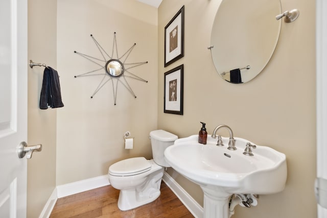 bathroom with hardwood / wood-style floors, sink, and toilet