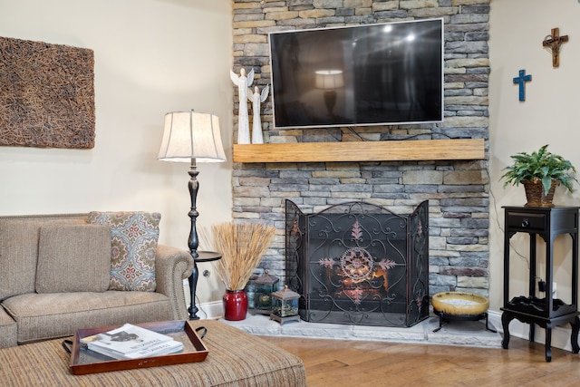 living room featuring a stone fireplace and hardwood / wood-style floors