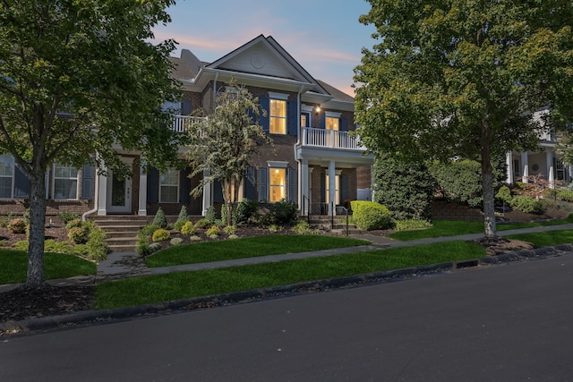 view of front of property featuring a balcony and a lawn