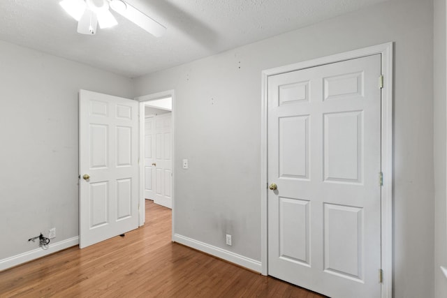 unfurnished bedroom with ceiling fan, hardwood / wood-style floors, and a textured ceiling