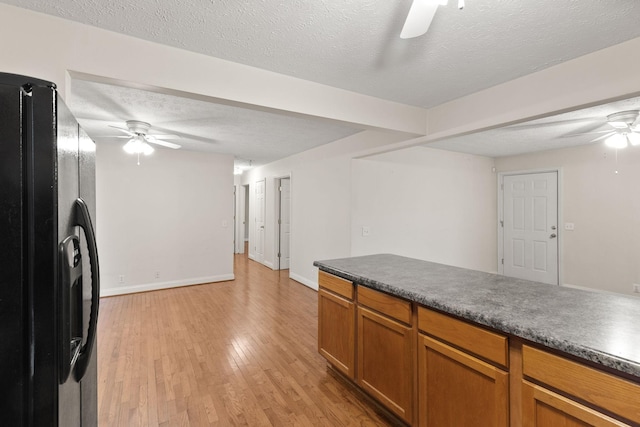 kitchen with ceiling fan, black refrigerator with ice dispenser, light hardwood / wood-style flooring, and a textured ceiling