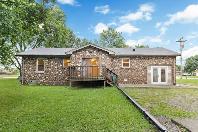 rear view of property featuring french doors, a deck, and a lawn