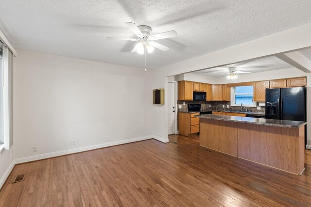 kitchen featuring black appliances, sink, dark hardwood / wood-style floors, a textured ceiling, and ceiling fan