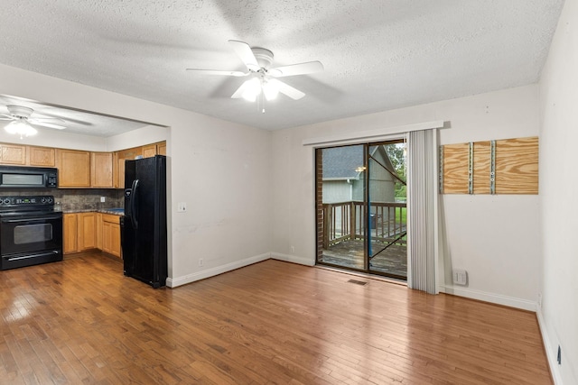 kitchen featuring a textured ceiling, dark hardwood / wood-style flooring, ceiling fan, decorative backsplash, and black appliances