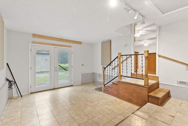 interior space featuring rail lighting, light tile patterned floors, ceiling fan, and french doors