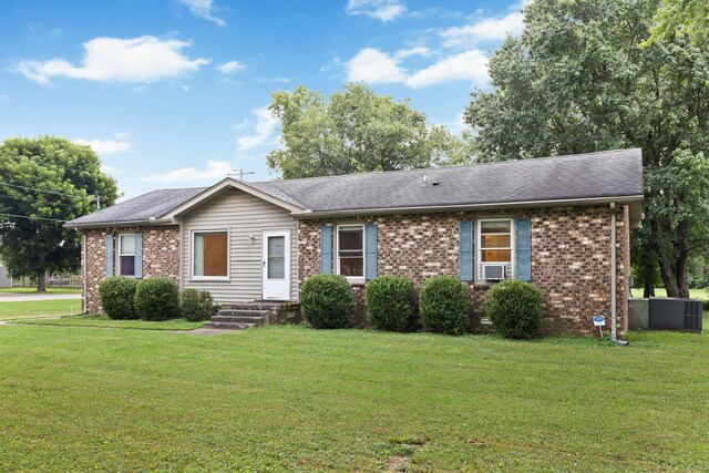 single story home with cooling unit and a front lawn