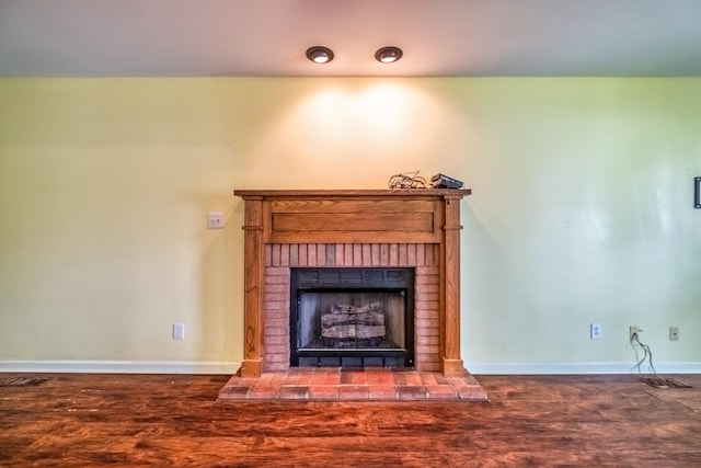 unfurnished living room with dark wood-type flooring and a fireplace