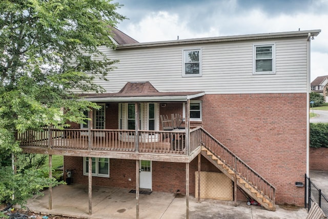 rear view of house featuring a wooden deck and a patio area