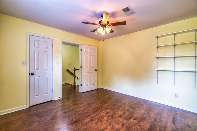 empty room featuring dark wood-type flooring and ceiling fan