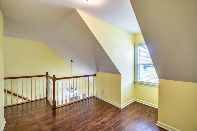 additional living space featuring dark wood-type flooring and vaulted ceiling