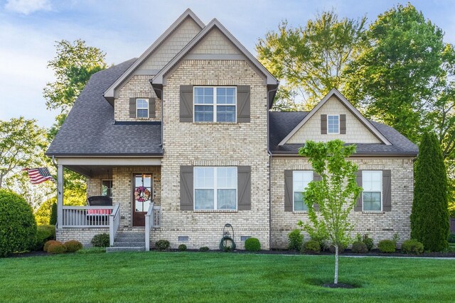 craftsman inspired home featuring a porch and a front lawn