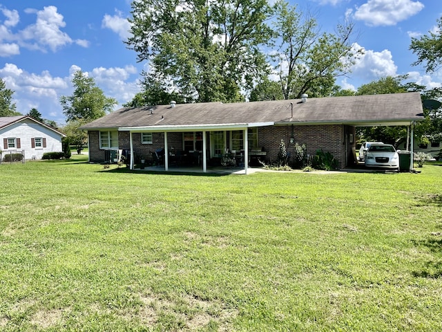 rear view of house featuring a lawn and a carport