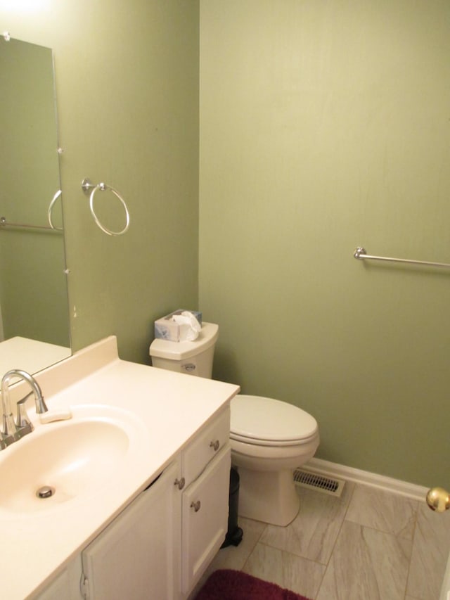 bathroom featuring toilet, vanity, visible vents, baseboards, and marble finish floor