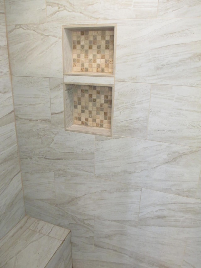 interior details with a tile shower