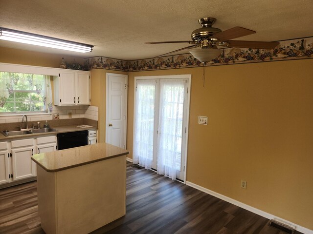 kitchen with sink, a textured ceiling, dark hardwood / wood-style flooring, dishwasher, and white cabinets