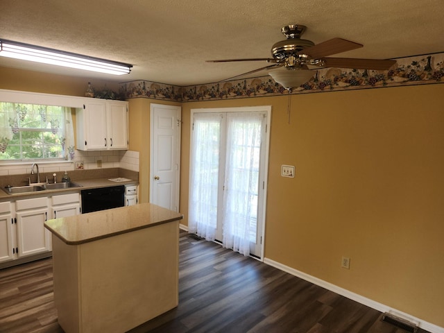 kitchen featuring black dishwasher, visible vents, a sink, and white cabinetry