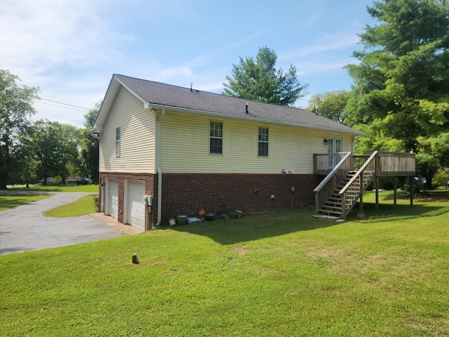 exterior space featuring a garage, driveway, a yard, stairway, and a wooden deck