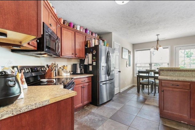 kitchen with pendant lighting, stainless steel appliances, a textured ceiling, and a notable chandelier