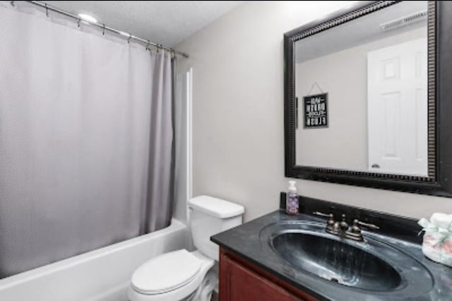 full bathroom with vanity, toilet, a textured ceiling, and shower / bath combo