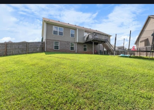 rear view of house with a deck and a lawn