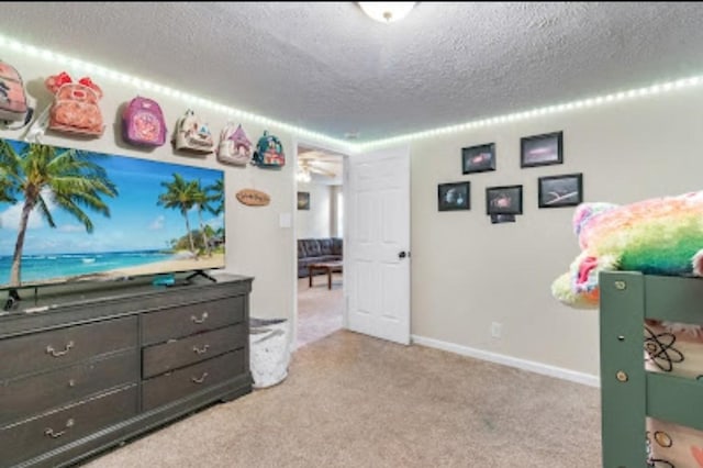 recreation room with light colored carpet and a textured ceiling