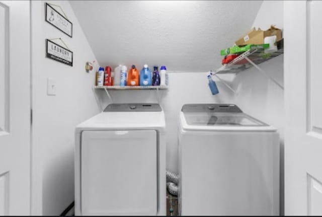 washroom with washer and clothes dryer and a textured ceiling