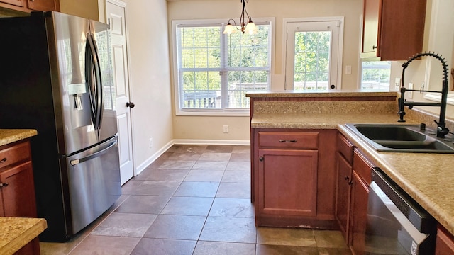 kitchen with sink, decorative light fixtures, a notable chandelier, stainless steel appliances, and tile patterned flooring